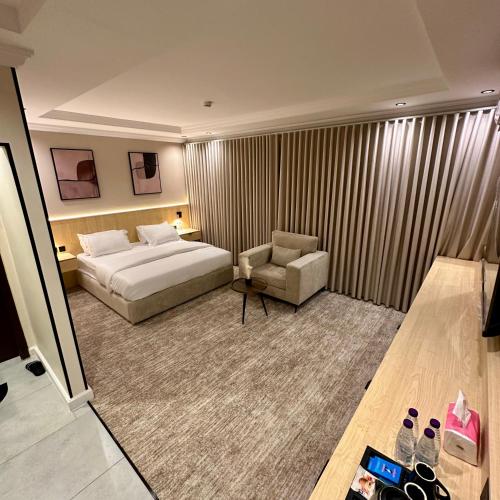 a hotel room with a bed and a chair at نسيم الحرم in Ash Shishah