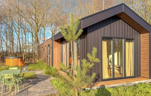 a small house with a black roof and a patio at Sernets Recreatie Chalet 112 in Oud-Gastel