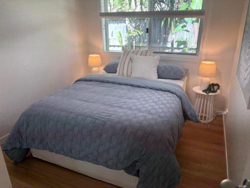 a bedroom with a large bed with a window at Beach Side Getaway Lighthouse Beach in East Ballina