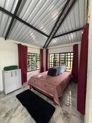 a bedroom with a bed in a room with red curtains at Cabaña DAYANAVA in Aguazul