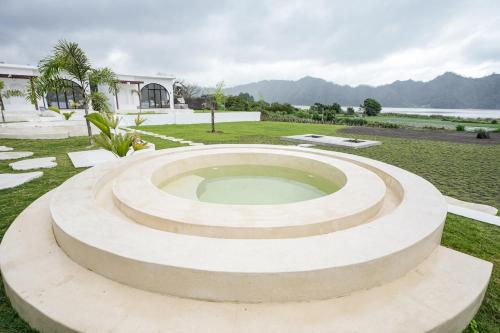 a large stone circle in a park with a building at Lazura Serenite in Bangli