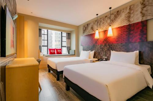 a hotel room with two beds and a window at Ibis Chengdu High-tech Tianfu Software Park in Chengdu