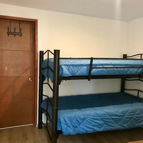 two bunk beds in a room with a door at Oasis Tequisquiapan in Tequisquiapan