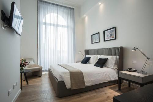 a white bedroom with a bed and a window at 7Florence in Florence