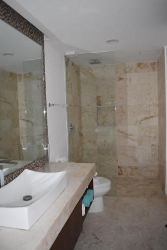 a bathroom with a sink and a toilet and a shower at Lux Condo Anah Downtown in Playa del Carmen
