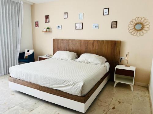 a bedroom with a large bed with a wooden headboard at Lux Condo Anah Downtown in Playa del Carmen