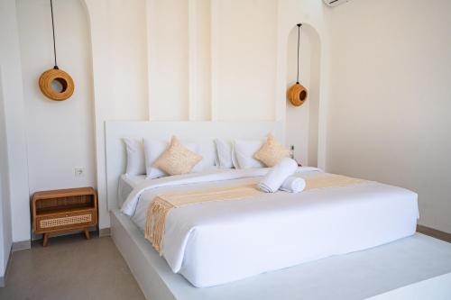 a white bedroom with two beds with white walls at Lazura Serenite in Bangli