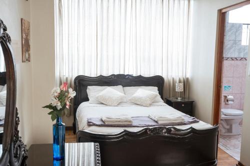 a bedroom with a black bed with towels on it at Moty's Guesthouse in Cusco
