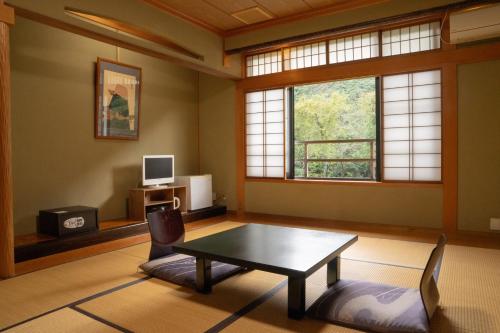 a living room with a table and a window at 銭がめ in Kanazawa