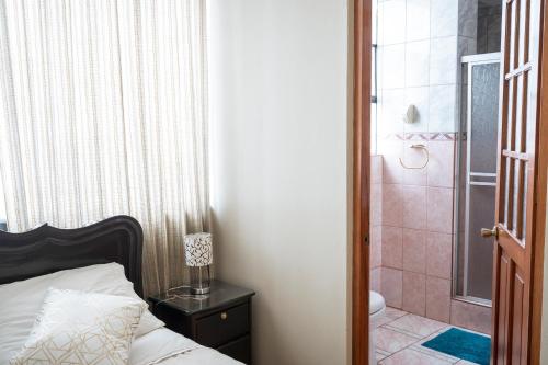 a bedroom with a bed and a bathroom with a shower at Moty's Guesthouse in Cusco