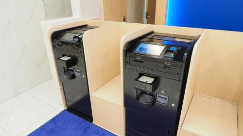 an atm machine in a room with a wall at Toyoko Inn Hirosaki Ekimae in Hirosaki