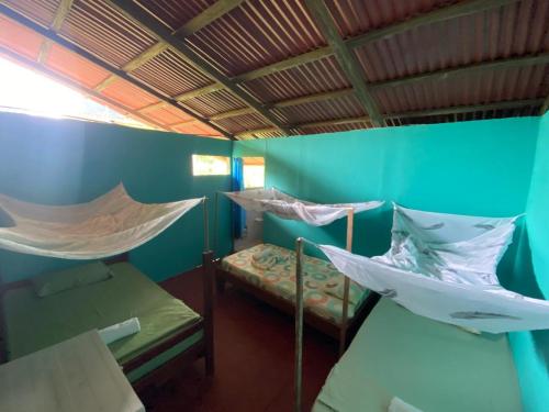 a room with two beds and a hammock in it at Posada Kevelin in Termales - agua caliente - nuqui