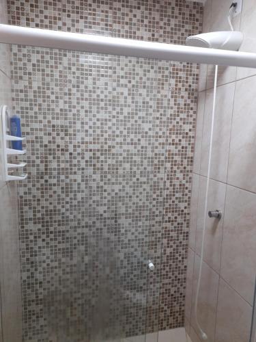 a bathroom with a shower with brown tiles at Casa Contêiner Azul in Rosário do Sul