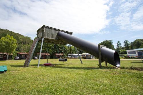 a slide in a park with a playground at Randbøldal Camping & Cabins in Randbøl