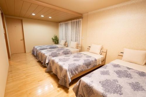 a room with four beds in a row in a room at 絆Kizuna in Yatomi 