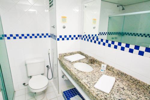 a bathroom with a sink and a toilet and a mirror at Vip Hotel in Jaú