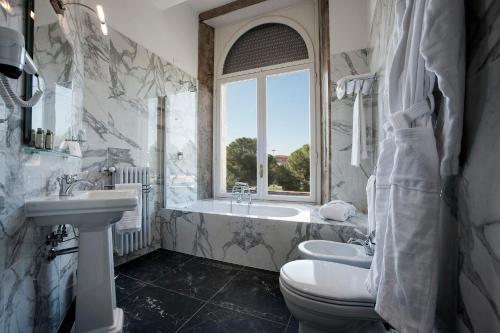 ein Badezimmer mit einer Badewanne, einem Waschbecken und einem WC in der Unterkunft 7Florence in Florenz