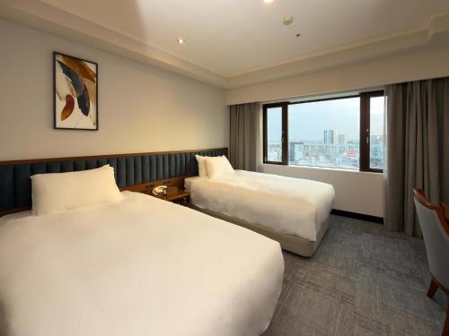 a hotel room with two beds and a window at ANA Crowne Plaza Chiryu by IHG in Chiryu