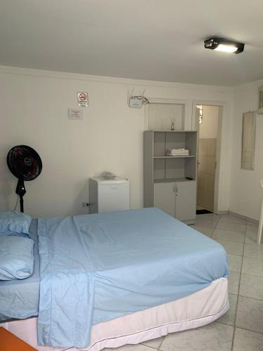 a bedroom with a large blue bed in a room at Boas Vindas in Guarujá