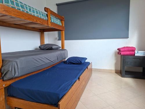 a bedroom with a bunk bed with blue sheets at Casa Adonai in Temixco