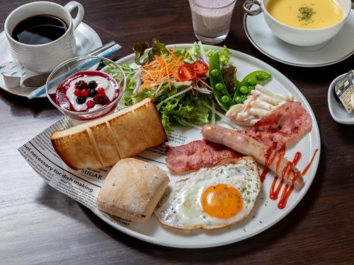 a plate of breakfast food with an egg and a salad at Awa Ikeda Station Hotel Eleven in Miyoshi
