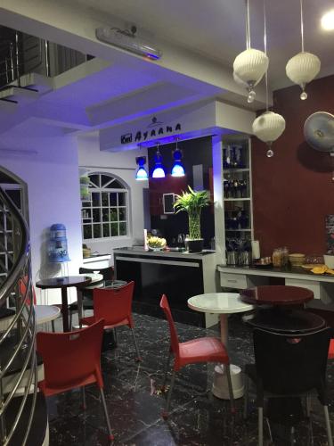 a restaurant with tables and chairs and blue lights at Ayaana Boutique Hotel in Kandy