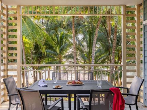 a table with a plate of fruit on a balcony at Mantra Amphora in Palm Cove