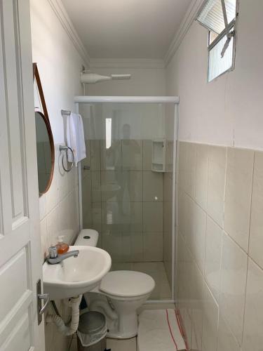 a bathroom with a toilet and a sink and a shower at Boas Vindas in Guarujá