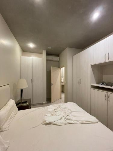 ein Schlafzimmer mit einem weißen Bett, einem Tisch und einer Lampe in der Unterkunft Bloco Escondido in Asunción