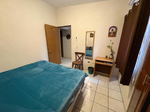 a bedroom with a bed and a table and a mirror at Casa compartida de 1 habitación a 10 min de la playa in La Paz