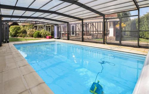 a large swimming pool with a retractable roof at Maison Avec Piscine Couverte in Fervaques