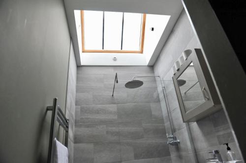 a bathroom with a walk in shower and a window at Ash House in Wincanton