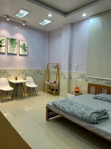 a bedroom with a bed and a table and chairs at Nature House Homestay in Ho Chi Minh City