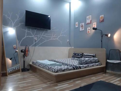 a bedroom with a bed and a flat screen tv at Nature House Homestay in Ho Chi Minh City