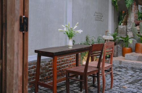 a table with two chairs and a vase with flowers on it at Sita Home in Danang