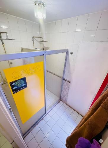 a bathroom with a shower with a yellow sign in it at Free Spirit Experience Guadalajara Centro in Guadalajara
