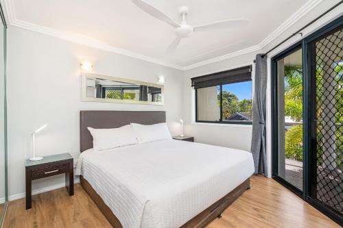a white bedroom with a bed and a window at Grange Resort Hervey Bay in Hervey Bay
