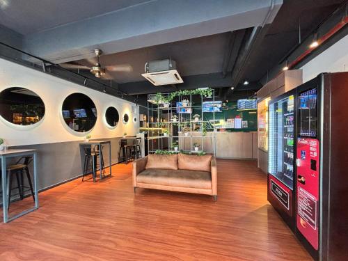 a room with a chair and a video game console at Smile Hotel Seri Kembangan in Seri Kembangan