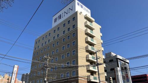 a tall building with a sign on top of it at Toyoko Inn Hokkaido Hakodate Ekimae Daimon in Hakodate