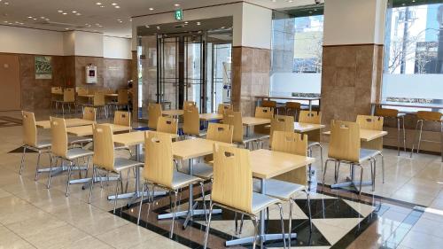 a cafeteria with tables and chairs in a building at Toyoko Inn Hokkaido Hakodate Ekimae Daimon in Hakodate