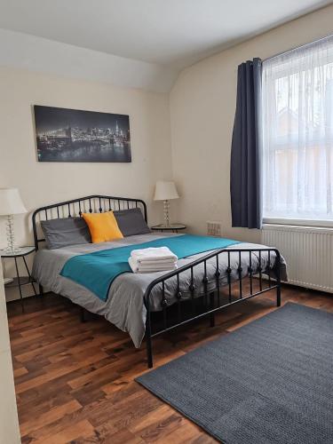 a bedroom with a bed with blue and orange pillows at King En-Suite Room Self-Catering Workspace in Hounslow