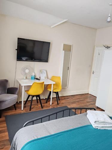 a bedroom with a bed and a table and chairs at King En-Suite Room Self-Catering Workspace in Hounslow