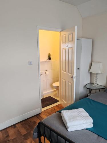 a bedroom with a bed and a bathroom at King En-Suite Room Self-Catering Workspace in Hounslow