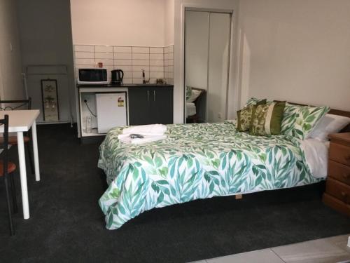 a bedroom with a bed and a table and a kitchen at Giulia Guests Rooms in Beechmont