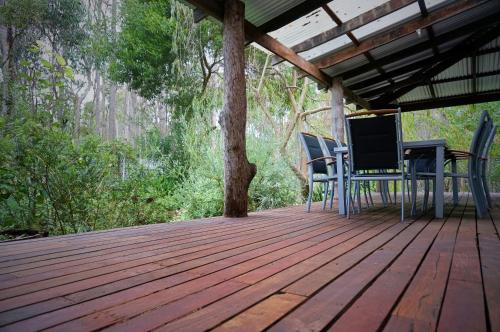 a wooden deck with chairs and a table on it at Banana Pancakes in Margaret River Town