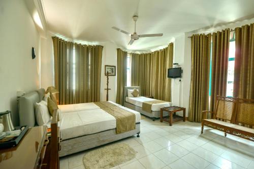 a bedroom with a bed and a living room at The Royal Mall in Kandy