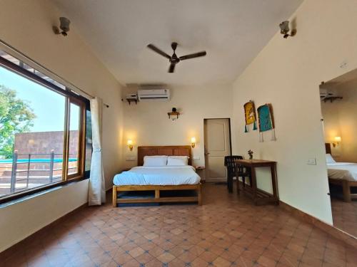 a bedroom with a bed and a large window at Nature yatra in Achra