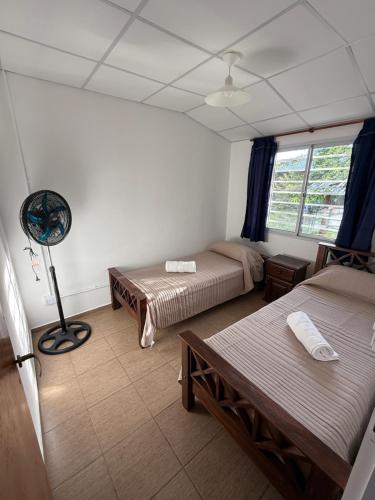 a room with two beds and a fan at Potrero Village Suites Refugios Serranos in Potrero de Garay