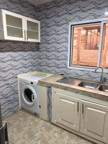 kuchnia z pralką i zlewem w obiekcie Room 17 w mieście Brufut
