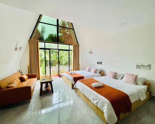 two beds in a room with a large window at Holy Villa in Kampot